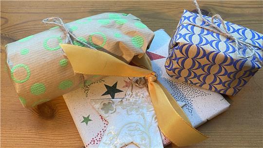 Drei verpackte Geschenke, mit Schleifenband. 