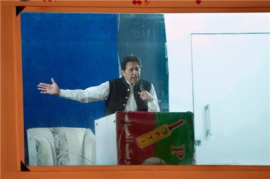 Geschützt durch eine kugelsichere Barriere spricht Imran Khan, ehemaliger Premierminister von Pakistan, während einer Kundgebung.  Khan ist wegen Ermittlungen in einem Korruptionsverfahren in Islamabad verhaftet worden.