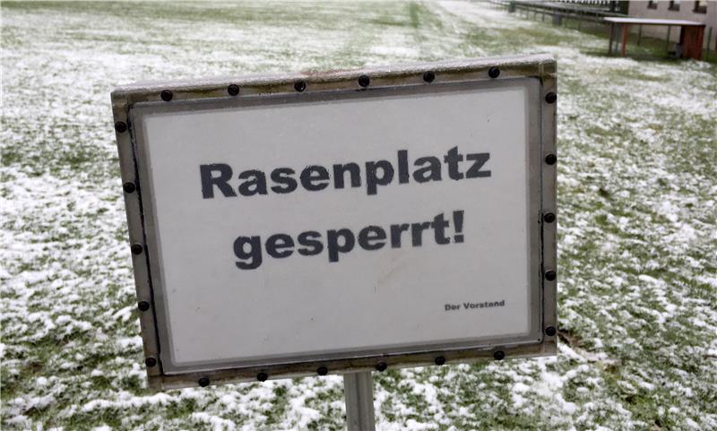 Auf einem Fußballplatz steht ein Schild mit der Aufschrift, dass dieser Platz gesperrt ist. 