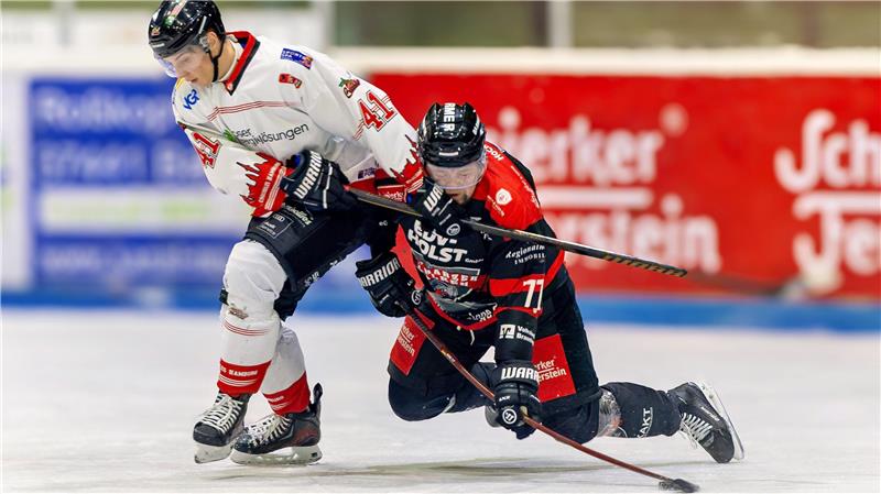 Ein Eishockeyspieler in Weiß und ein Eishockeyspieler in Schwarz und Rot kämpfen um den Puck.