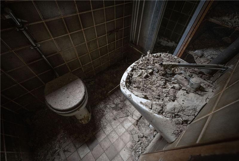 Wüst pocht auf Pflichtversicherung für Elementarschäden Getrockneter Schlamm im ehemaligen Badezimmer eines verlassenen und bei der Flut im Jahr 2021 zerstörten Hauses im Ahrtal zeugen noch immer von der Wucht der Wassermassen.