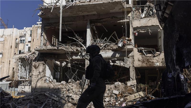 Silhouette einer Person mit Helm vor einem stark beschädigten, teilweise eingestürzten Gebäude