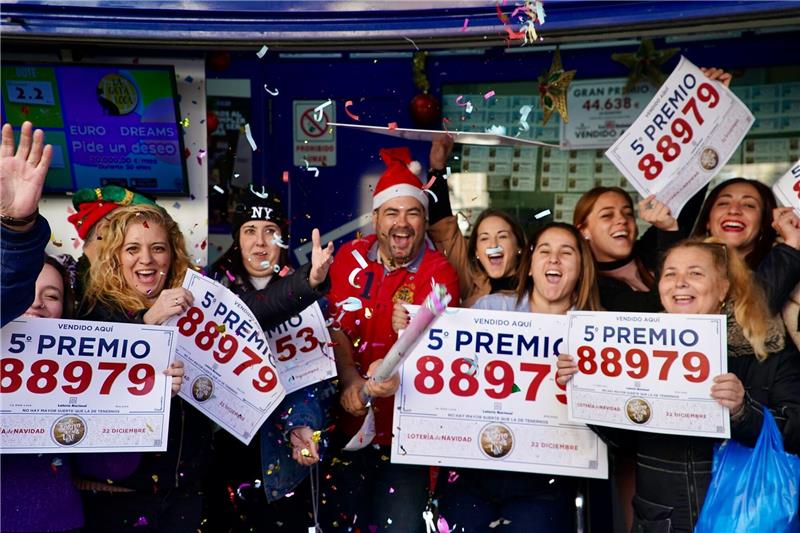 Gewinner der Weihnachtslotteriepreise feiern vor einer Lottoannahmestelle in Málaga.
