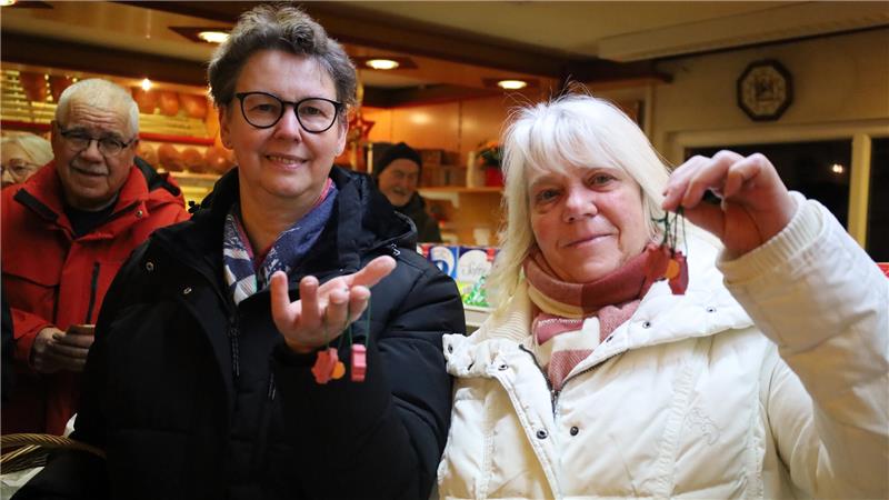 Zwei Frauen halten Glücksschweinchen hoch