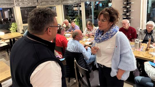Das Foto zeigt einen Mann, der sich mit einer Frau unterhält.