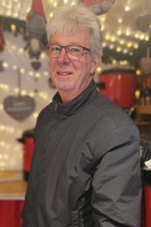 Viele Weihnachtsmärkte öffnen vor Totensonntag – Goslar nicht Glühweinwirt Willi Robben steht in seinem Stand und guckt in die Kamera. Er trägt eine schwarze Jacke und eine Brille.