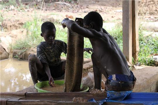 Goldverarbeitungsanlage in der Region Brong-Ahafo in Ghana: Zwei kleine Jungen waschen das Erz, um es vom Schlamm zu trennen.