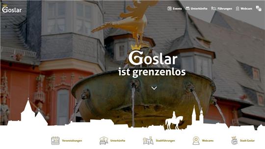 Brunnen mit goldener Adlerfigur vor historischem Fachwerkhaus in Goslar.