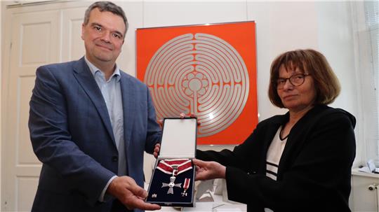 Zwei Personen präsentieren einen Orden.