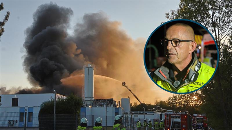 Rauchwolken über einem Industriegebäude mit Feuerwehrleuten und Löschfahrzeugen im Vordergrund sowie einem Einsatzleiter im eingefügten Kreisbild.