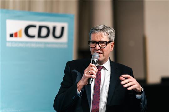 Ein Mann spricht in ein Mikrofon.