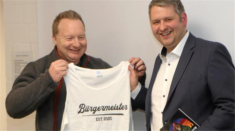 Schladen-Werla wählt Martin Schulze zum neuen Bürgermeister Gratulation zur Bürgermeisterwahl: Michael Petrick (l.), Fachbereichsleiter bei der Gemeinde Schladen-Werla, überreicht seinem künftigen Chef Martin Schulze das passende Shirt.