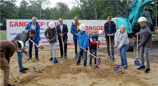 Greifen beim ersten Spatenstich für das Kinderhaus der Lebenshilfe gemeinsam zu Schaufel und Spaten: (hinten v.l.) Bürgermeister Ralf Abrahms, Architekt Hendrik Welp aus Braunschweig, Lebenshilfe-Geschäftsführer Clemens Ahrens, Hausleiter Benjamin Friebel und (vorn) die künftigen Bewohner. Foto: Nachtweyh
