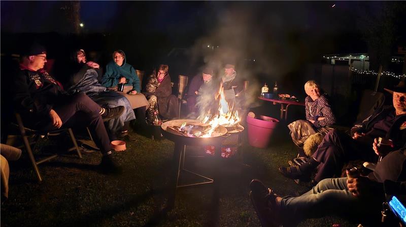 Campingplatz Prahljust: Wenn Menschen ihr Zuhause abreißen müssen Viele Camper sitzen um ein Lagerfeuer herum.
