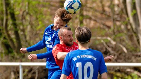 Groß Döhrens Dennis Koch im Kopfballduell mit Vienenburgs Julian Laue. Im Vordergrund beobachtet Dariusz Makowski die Szene.Foto: Drechsler