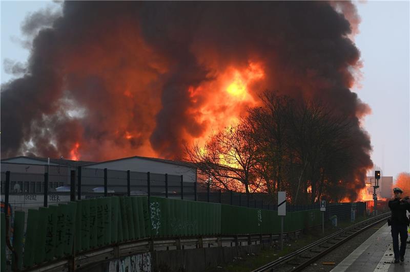 Hamburg im Rauch nach Großbrand Großbrand bei einem Autohandel in Hamburg: Flammen lodern, Rauch steigt auf.