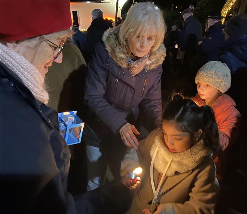 Ein Kind entzündet eine Kerze und gibt das Friedenslicht weiter.