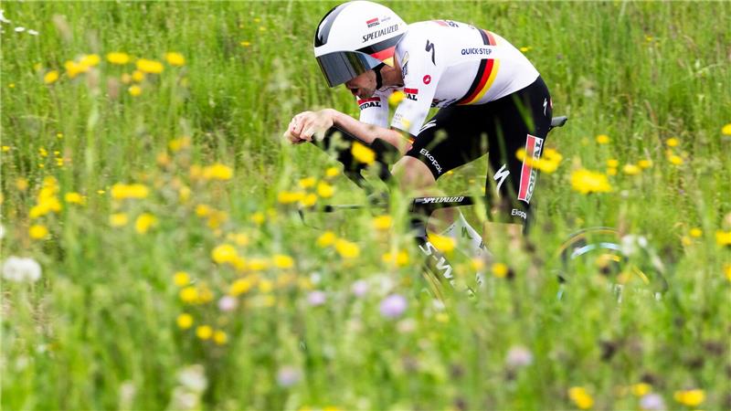 Grüner Sport: Maximilian Schachmann aus Deutschland fährt bei der Tour de Romandie durch blühende Wiesen.