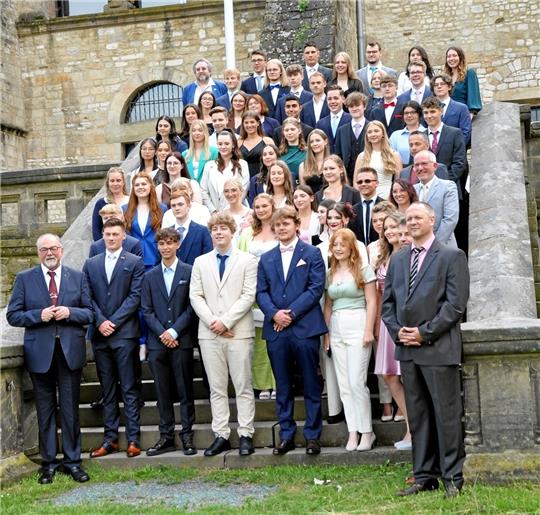 Gruppenbild vor der Pfalz: der Abitur-Jahrgang 2023 des Ratsgymnasiums mit Direktor Hans-Peter Dreß (li.) und Vize Michael Kwasniok (re.) vorn und den vier Tutoren Jessica Voll, Marc Schweter, Jürgen Burgdorf und Stefan Bolde-Müller mittendrin. Foto: Heine