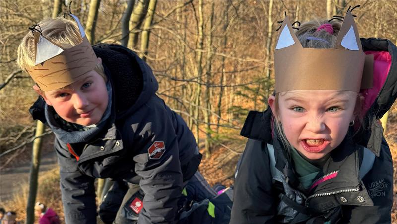 Colin (l.) und Emma-Lou aus der Grundschule Vienenburg schauen in die Kamera und tragen Luchsohren aus Pappe.
