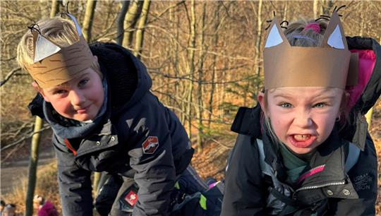Colin (l.) und Emma-Lou aus der Grundschule Vienenburg schauen in die Kamera und tragen Luchsohren aus Pappe.
