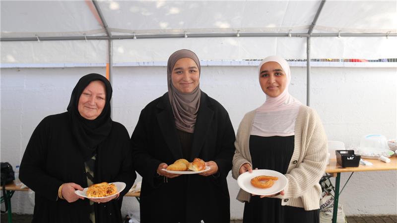 Hacer Özen (von links), Maryam Hammadi und Sarah Hammadi bieten Gebäck an.