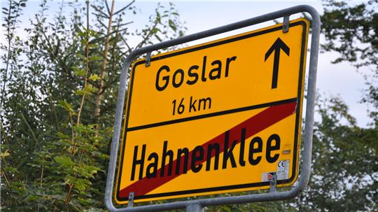 Gelbes Ortsausgangsschild mit rotem Schrägstrich durch den Ortsnamen 'Hahnenklee' und Pfeil mit Entfernungsangabe 'Goslar 16 km'