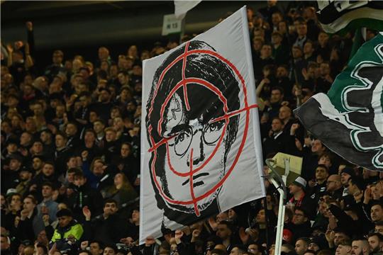 Hannover-Fans halten ein Fadenkreuz-Plakat mit dem Gesicht des Film-Zauberers Harry Potter hoch.