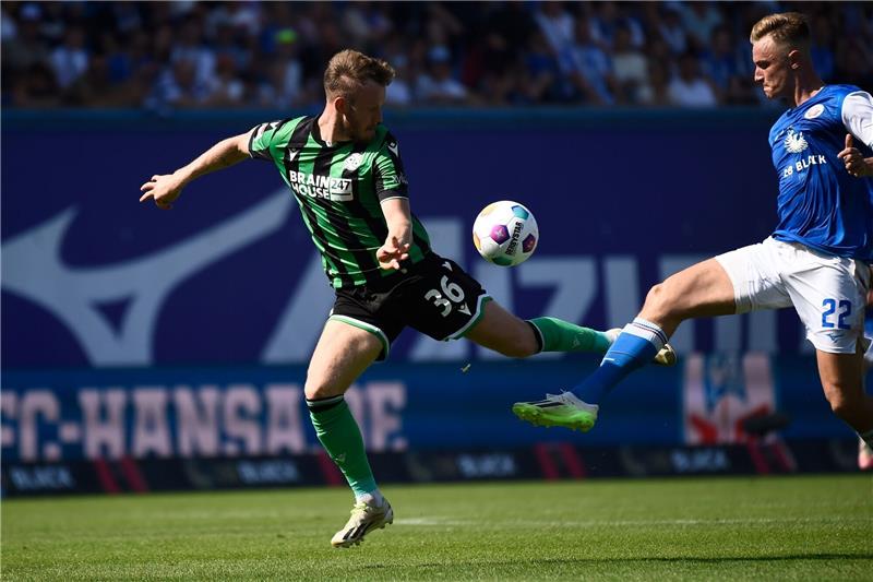 Hannovers Cedric Teuchert (l-r) und Rostocks Jasper Van Der Werff kämpfen um den Ball.