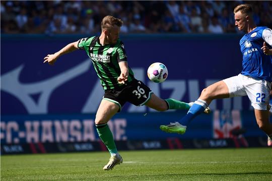 Hannovers Cedric Teuchert (l-r) und Rostocks Jasper Van Der Werff kämpfen um den Ball.
