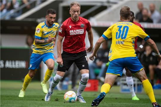 Hannovers Havard Nielsen (M) spielt gegen Braunschweigs Brian Behrendt (r).