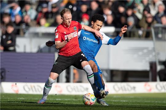 Hannovers Havard Nielsen (l) spielt gegen Magdeburgs Luka Sliskovic.