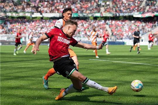 Hannovers Jannik Dehm schießt gegen Kiels Fabian Reese auf das Tor.