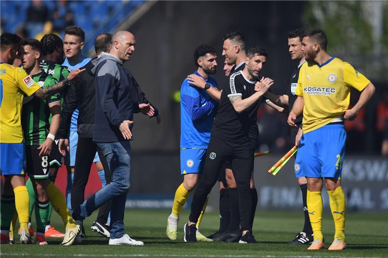 „Qualität war Mangelware”: Hannover hakt den Aufstieg ab Hannovers Trainer Stefan Leitl (3.v.r) und Braunschweigs Trainer Daniel Scherning stehen nach dem Schlusspfiff auf dem Feld.