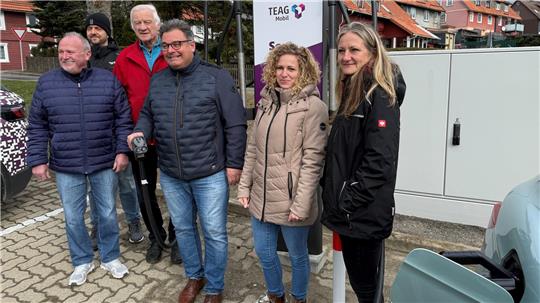 Das Foto zeigt zwei Frauen und vier Männer vor einer Elektro-Ladesäule.