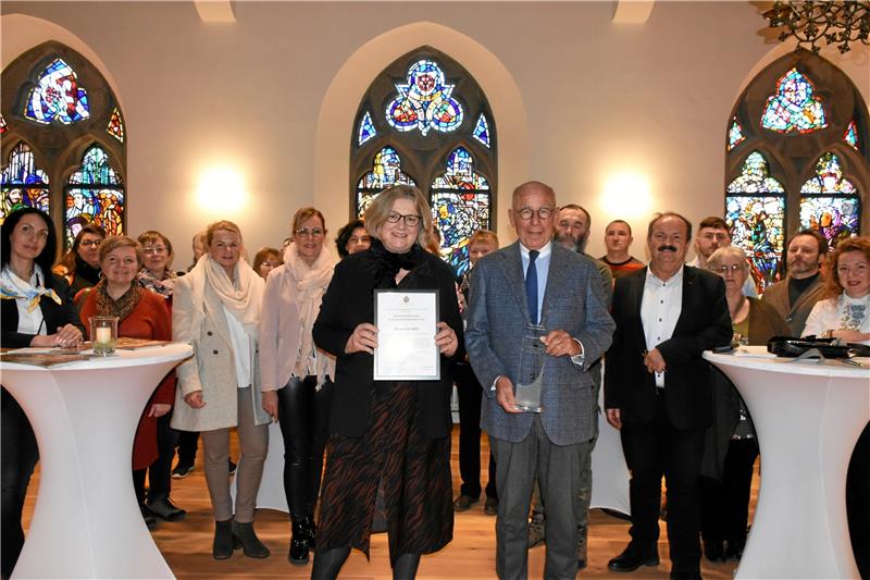 „Goslar hilft Menschen in und aus Krisengebieten“ wird geehrt Hans-Joachim Tessner lässt es sich nicht nehmen, auch den 10. Bürgerpreis der Tessner-Stiftung mit Begleitung der anderen Juroren persönlich zu überreichen. Dr. Christine Rose nimmt ihn stellvertretend für alle Mitglieder ihres jungen Vereins „Goslar hilft Menschen in und aus Krisengebieten“ und dessen Partnern entgegen; einen Teil davon hat sie zur Feierstunde auf die Rathausdäle mitgebracht. Foto: Kempfer