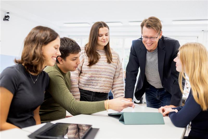 Harald Zeiss von der Hochschule Harz beschreibt die Stärken der Region Studenten sitzen mit einem Professor an einem Tisch.