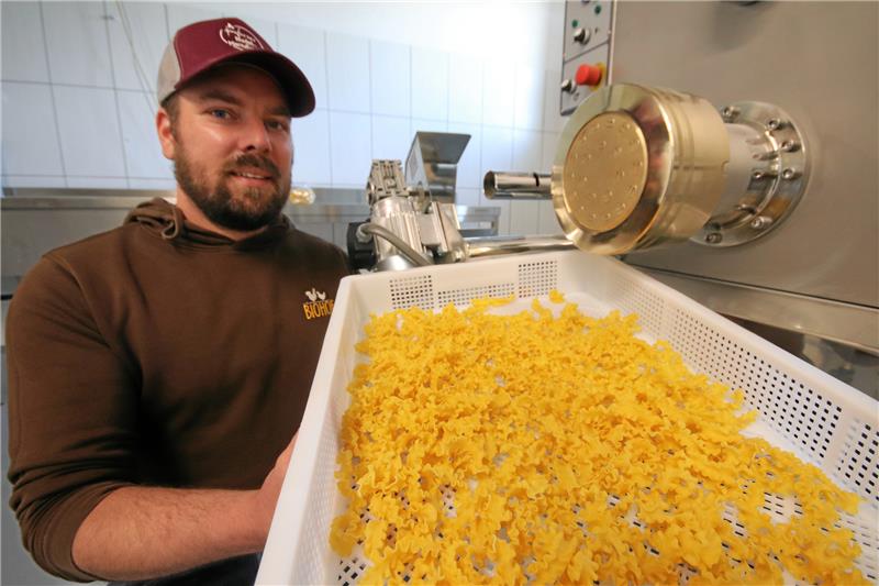 Wie ein Bio-Hof mit eigener Nudelei die Wertschöpfung erhöht Hauke Gaus steht an der Nudelmaschine, die in diesem Juni ihre Arbeit aufnehmen wird. Fürs Foto hat er schon einmal ein paar fertige Spirelli in die Trockenschale geschüttet. Foto: Gereke