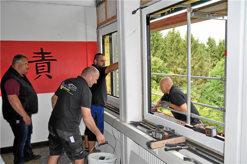 Hausmeister Thomas Bremer (l.) ist auch in den Ferien gefordert, denn die diversen Bauarbeiten müssen koordiniert werden. Hier werden gerade neue Fenster eingebaut.