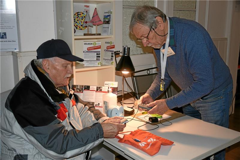 Goslarer Reparaturwerkstatt: Die Männer mit dem „Magic Touch“ Heinrich Macke-Lowin (re.) nimmt im Flur einen Auftrag entgegen. Foto: Kempfer