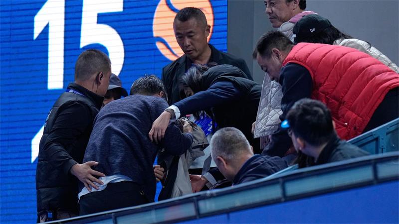 102. Turniersieg: Tennisstar Djokovic triumphiert in Peking Helfer kümmern sich um einen Mann, der von einem Ball verletzt wurde, den der Russe Medwedew in die Zuschauerränge geschlagen hatte.