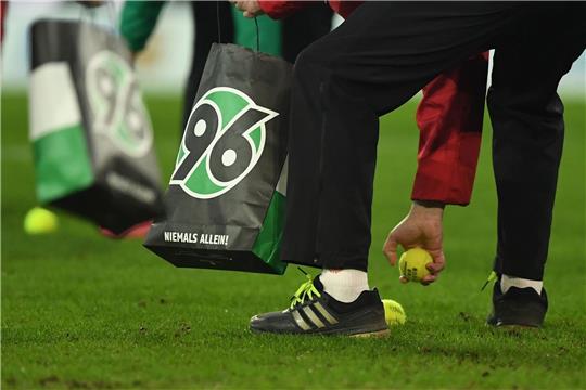 Helfer sammeln Tennisbälle vom Spielfeld.