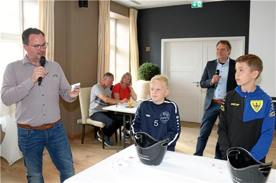 Henning Bartel (li.), Leiter Lesermarkt der Goslarschen Zeitung, liest das Los vor, das Sven-Ole Immenroth (2. v. l.) und Louis Hartung gezogen haben. Lutz Scheibel, Gesamtleiter Vermarktung, hört aus dem Hintergrund zu.  Fotos: Sowa