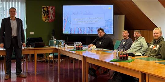 Henning Hildebrand erklärt den Hausmeistern aus der Region im Ratssaal des Rathauses Braunlage, wie der Energieverbrauch in öffentlichen Gebäuden gesenkt werden kann.