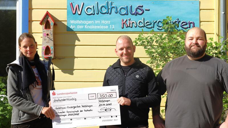 Henrik Stein und Robin Habig (r.) übergeben den Erlös aus der letzten Party in der Festhalle Wolfshagen an Kerstin Brandt, Waldhaus-Kindergartenleitung Wolfshagen.