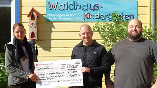 Henrik Stein und Robin Habig (r.) übergeben den Erlös aus der letzten Party in der Festhalle Wolfshagen an Kerstin Brandt, Waldhaus-Kindergartenleitung Wolfshagen.