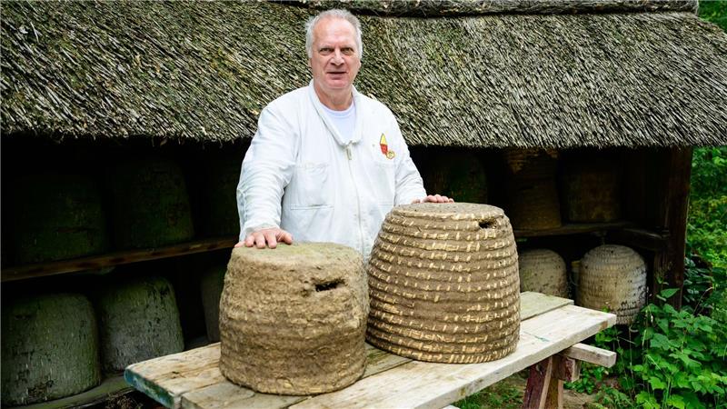 Trend zum Imker - Kiekeberg vermittelt Wissen Hermann Benesch, Vorsitzender des Imkervereins am Kiekeberg e.V., steht auf dem Museumsgelände vor historischen Bienenstöcken.