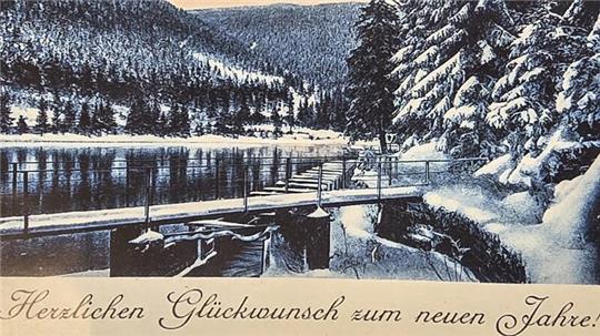 Winterliche Landschaft mit schneebedeckten Tannen, einem See und einer Brücke im Vordergrund, darüber der Text 'Goslar Herzbergerteich' und darunter 'Herzlichen Glückwunsch zum neuen Jahre.