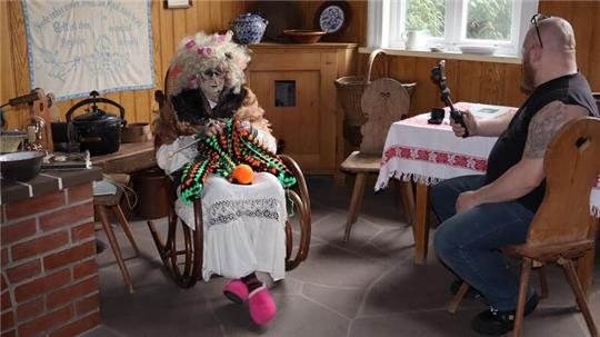 Strickende Hexe im Schaukelstuhl. 