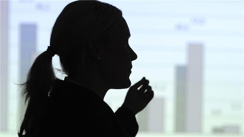 Hier erklärt eine Frau eine Statistik an der Wand - vielleicht eine Mutter, die sich bald um ihre Kinder kümmern muss? (Illustration)